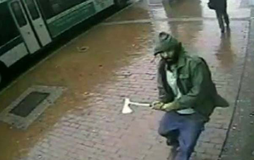 A hatchet-wielding man who charged at four rookie New York City police officers Thursday as they posed for a photograph on a Queens street